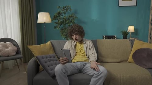 Cheerful Man Video Calling on Tablet Computer at Home