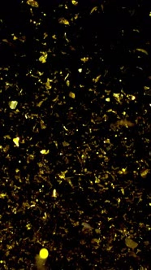Falling Golden Confetti on Black Background