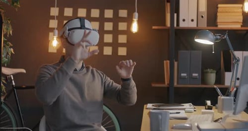 Carefree Employee Using Virtual Reality Glasses Wearing Headset Relaxing in Office at Night