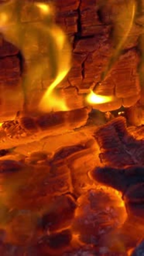 Vertical Flames Licking Charred Wood Up Close