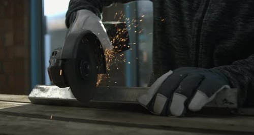 Person Grinding Metal Bar with Sparks