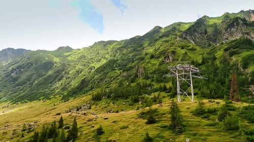 Power line supports installed in the green mountains.
