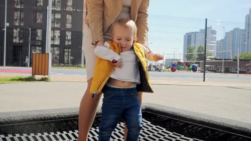 Mother and Child Bouncing on Trampoline Together