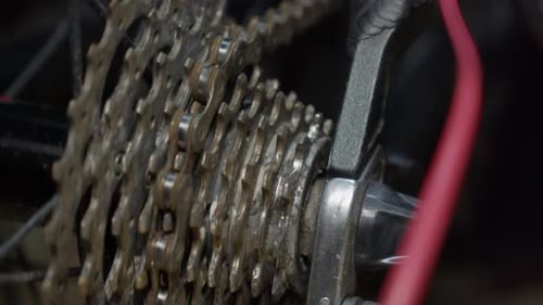 Close up of bicycle rear sprocket as bike chain slowly spins wheel