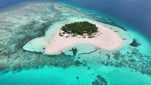 Aerial view of Patawan Island surrounded by coral reefs and pristine turquoise waters in Balabac