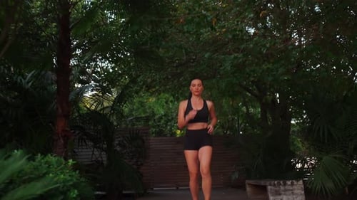 Middle Age Woman Jogging Summer Day in City Park