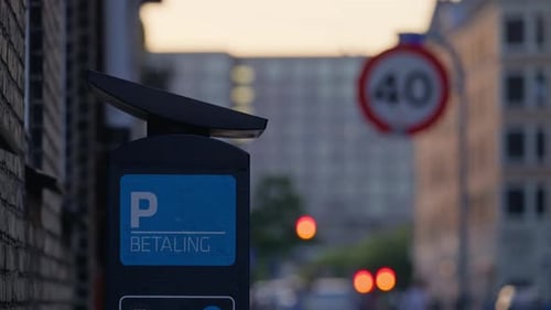 Parking meter displaying ''Betaling'' meaning payment in a city street scene at sunset. Copenhagen,