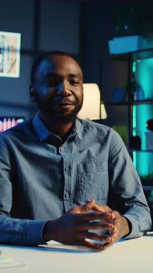 Young Man Speaking at Desk in Office Setting
