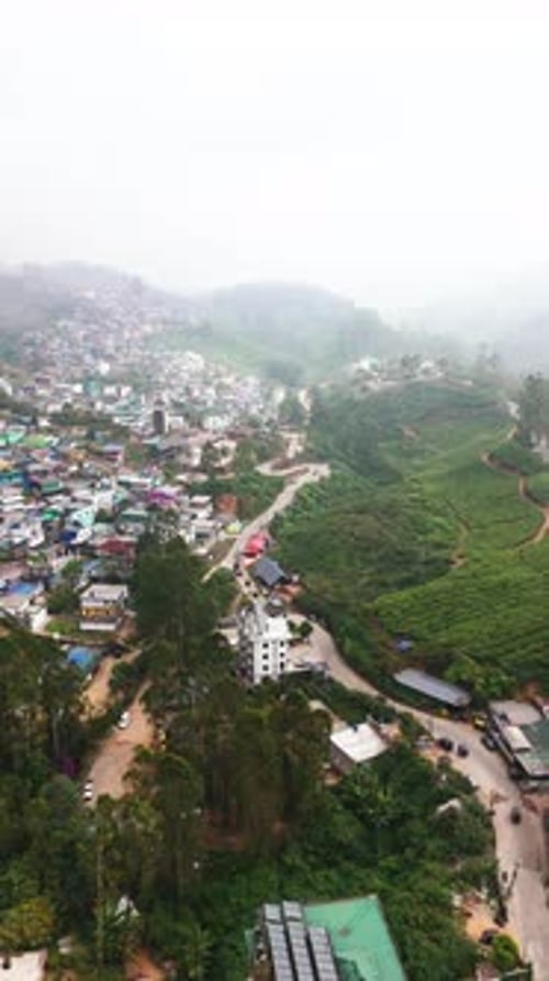 Drone vertical filmé au-dessus de la station de montagne de Munnar, jour brumeux en Inde