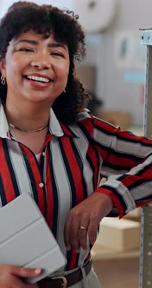 Woman Smiling, Holding Tablet Leaning on Shelf