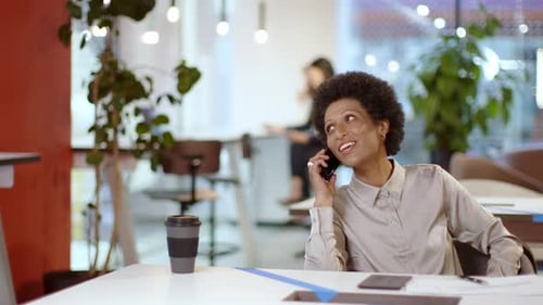 Businesswoman sitting in office talking on the phone