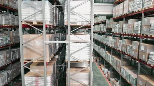 Warehouse Aisle with Stacked Pallets and Boxes in Storage Racks
