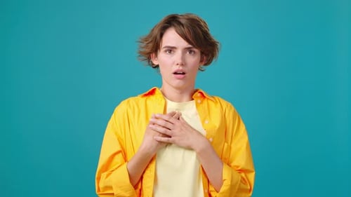 Confused Woman Expressing Discontent on Teal Background