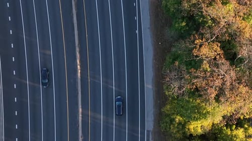 Una vista aérea de arriba hacia abajo sobre una carretera en cámara lenta. La cámara del Zumbido inclinada hacia abajo, la plataforma rodante hacia arriba