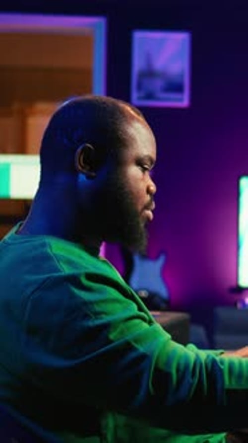 Smiling Man Plays Keyboard at Home at Night