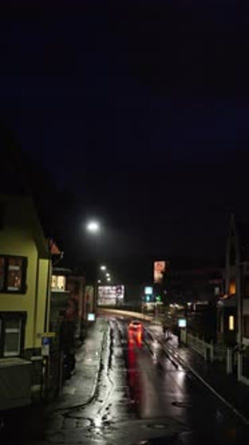 A Beautifully Atmospheric Rainy Night Street Scene Featuring a Car in the Cityscape