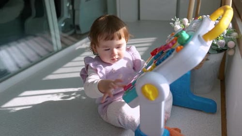 Infant Plays with Colorful Toy at Home