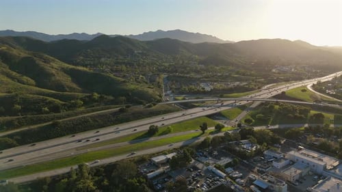 This Aerial View Captures the Los Angeles Suburbs Showcasing the Freeway Against a Beautiful Sunset