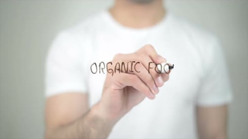 Man Writes Organic Food on Transparent Surface