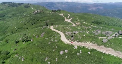 Off-road red rally car in dirt terrain speeding down a mountain. Red rally car racing on a dirt road
