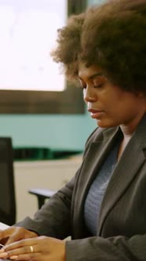 Femme afro concentrée travaillant à l'aide d'un ordinateur dans un espace de coworking