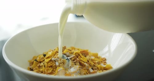 Pouring Milk into Cereal Bowl in Morning Light
