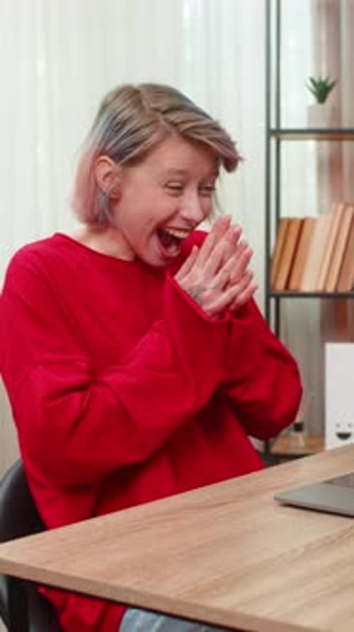 Excited Woman Using Laptop at Desk Indoors
