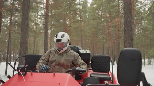 Snowy ATV Adventure Rider Dressed in Camouflage Preparing for Challenging Trail Snowcovered Terrain