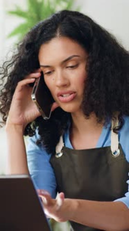 Young Woman Talking on Phone While Using Laptop