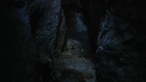 Strömendes kristallklares Wasser tief in einer engen Schlucht, in die kaum Licht eindringt