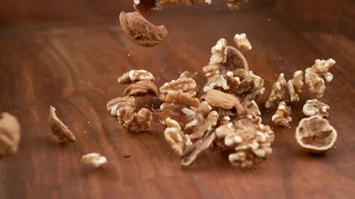 Walnuts Falling on Wooden Background in Slow Motion