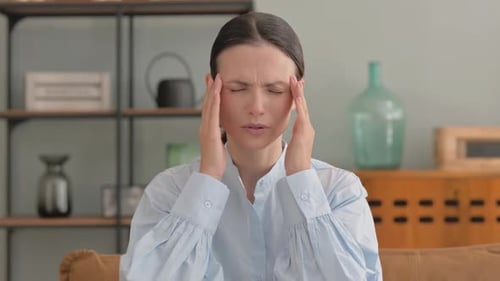 Portrait of Young Woman with Headache at Home