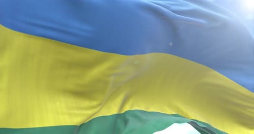 Realistic Waving Flag of Rwanda Against Blue Sky