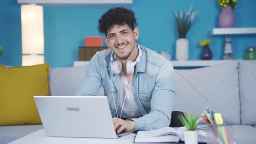 Young college student looking at camera and laughing. He is making a positive gesture.