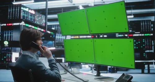 Un corredor de bolsa profesional habla por teléfono de escritorio, estación de trabajo de negociación con múltiples monitores en la bolsa de valores