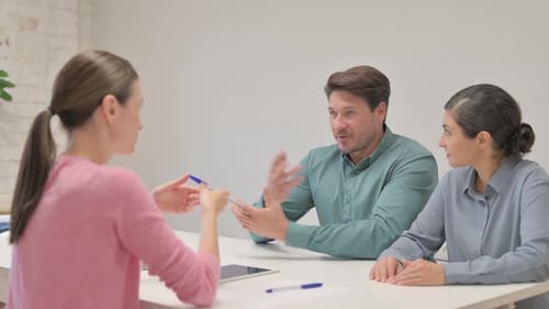 Junge Frau spricht mit Teamkollegen im Büro