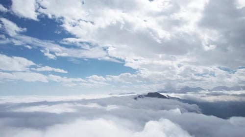 Aerial Drone View Of Layers Of Clouds In The Sky over mountains. Tilt Down Shot