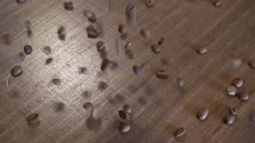 Coffee Beans Falling on a Wooden Table