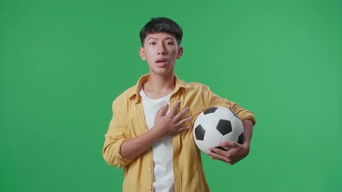 Asian Boy With A Ball Singing National Anthem While Cheering Soccer On Green Screen Background