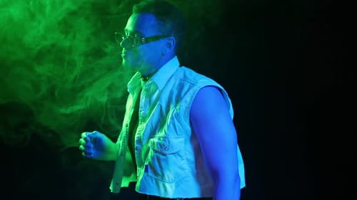 Glamouröser Mann in neongrünem Licht, Nachtclub-Porträt eines sexy Kerls, der tanzt