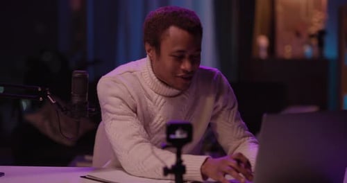 Man Recording a Podcast with Professional Microphone at Desk