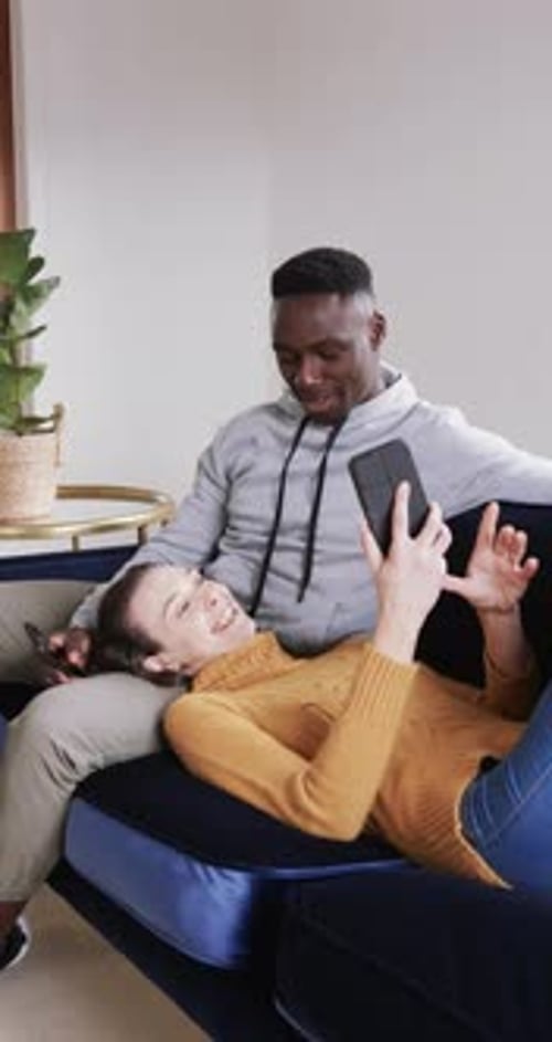 Woman Lying on Lap Looking at Phone With Man