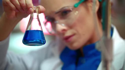 Closeup of Female Scientist Mixing Chemical Liquid in Lab Flask. Close Up