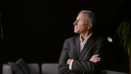 Elderly Businessman Reflecting Thoughtfully in Modern Office Setting