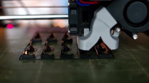 3D-Drucker arbeitet beim Zusammenbau eines schwarzen Kunststoffobjekts im Werk