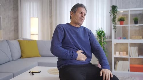 Mature man has stomach ache.