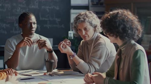 Des étudiants diversifiés et un professeur d'anglais utilisant des flashcards pendant la discussion
