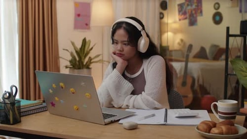 Teen Studying with Laptop and Headphones