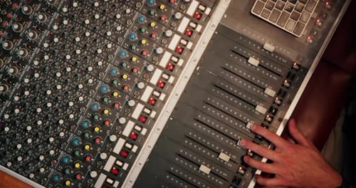 Above, hands and sound engineer in music studio with equipment, change volume and album production