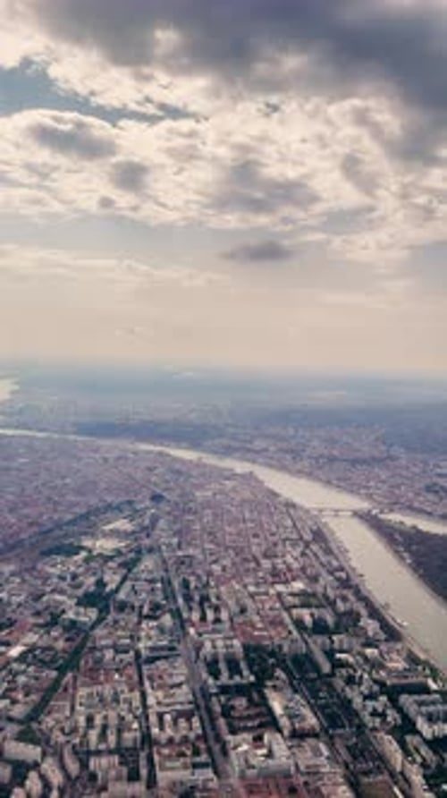 A view from an airplane window of a river and the buildings of a large city. The plane lands.